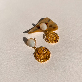 Détail posé des boucles doreilles Alma dorées en nacre blanche pour oreilles posées ou clips