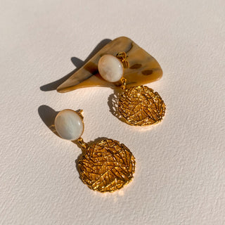 Zoom sur les boucles d'oreilles Alma dorées en nacre blanche pour oreilles percées et clips 