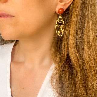 Boucles d’oreilles Tara graphiques et colorées portées, montrant la longueur, les couleurs et le mouvement, disponibles en version percées ou clips.