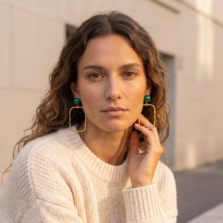 Boucles d'oreilles pendantes et graphique dorées avec pierre naturelle malachite pour oreilles percées et clips, photo portée de face.