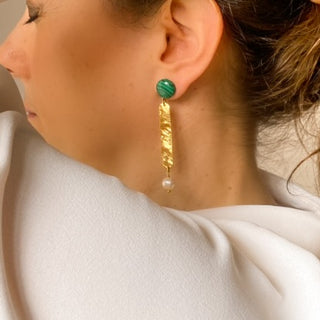 Boucles d’oreilles Cléo pendantes dorées en malachite verte et perles blanches portées, montrant la longueur, l’éclat de la dorure et les nuances des pierres disponibles, disponibles en percées ou clips.