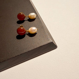 Zoom sur les boucles d'oreilles Colette en cornaline rouge et perles blanches