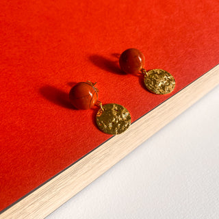Boucles d’oreilles Doris pendantes dorées, détail posé mettant en valeur le jaspe rouge, la texture et la finition dorée.
