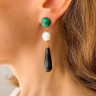 Boucles d’oreilles Felix pendantes dorées en malachite, perle naturelle et onyx noir portées, montrant la longueur, le mouvement et le contraste des trois pierres, disponibles en percées ou clips.