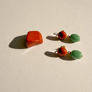 Boucles d’oreilles Fern dorées, détail posé mettant en valeur les pierres naturelles, l’aventurine verte, le jaspe rouge et la finition en or fin 24 carats.