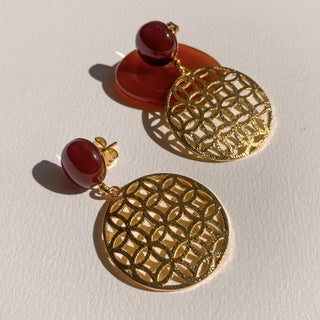 Boucles d’oreilles Flavie en cornaline rouge et doré, détail posé mettant en valeur la pierre, les nuances et la finition dorée, disponibles en version percées ou clips.
