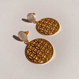 Boucles d’oreilles Flavie en nacre blanche et doré, détail posé mettant en valeur la nacre, les nuances et la finition dorée, disponibles en version percées ou clips.