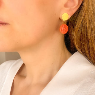 Boucles d’oreilles Gala pendantes en galuchat orange portées, montrant la longueur de 3,5 cm et la taille du pendant en galuchat (1,5 cm), disponibles en percées ou clips.