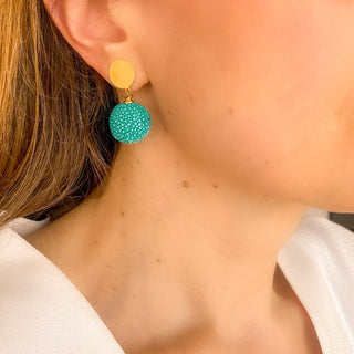 Boucles d’oreilles Gala pendantes en galuchat turquoise portées, montrant la longueur de 3,5 cm et la taille du pendant en galuchat (1,5 cm), disponibles en percées ou clips.