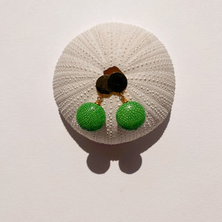 Boucles d’oreilles Gala en galuchat vert pomme, détail posé mettant en valeur la texture du galuchat et la finition dorée à l’or fin 24 carats.  