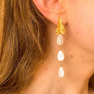 Boucles d’oreilles Zephyr pendantes dorées en perles blanches naturelles portées, montrant la longueur, le mouvement et l’éclat des perles.