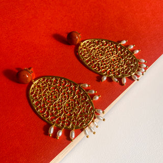 Boucles d’oreilles Scarlett pendantes dorées, détail posé mettant en valeur le jaspe rouge, les perles naturelles et la finition dorée.