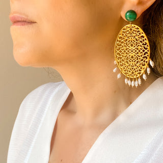 Boucles d’oreilles Scarlett pendantes dorées en malachite et perles naturelles portées de profil, montrant la longueur, le mouvement et l’éclat des pierres, disponibles en percées ou clips.