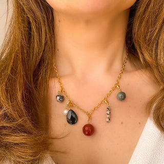 Collier charms Cerise Youm porté, tombé délicat sur le décolleté, rendu lumineux et ludique grâce au charms interchangeables en pierres et perles.