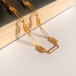 Collier Enzo doré, détail posé mettant en valeur la texture de la chaîne et la finition dorée.