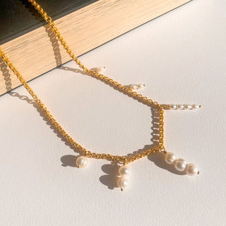 Collier Liv doré avec perles blanches, détail posé mettant en valeur les perles, les nuances et la finition dorée.