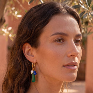 Créole Eloïse Youm en laiton doré à l’or fin 24K avec des charms en pierres et perles naturelles, à composer avec d'autres charms, photo portée.