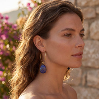 Grande créole dorée Youm avec charm interchangeable en lapis‑lazuli, photo portée.