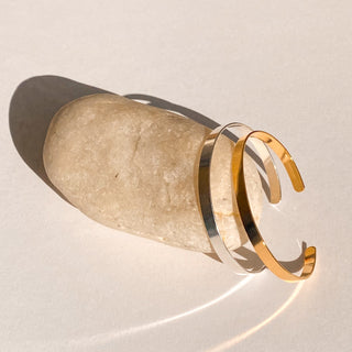 Joncs Ana doré et argenté, détail posé mettant en valeur la texture graphique, la finesse de 0,5 cm et la finition en or fin 24 carats.
