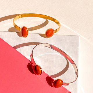 Joncs Théo argenté et doré, détail posé mettant en valeur la pierre naturelle de jaspe rouge, et les finitions des bracelets argentés et dorés.