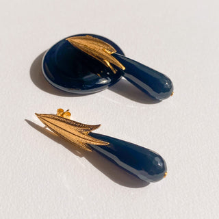 Boucles d’oreilles Armelle dorées, détail posé mettant en valeur l’onyx noir, la finition dorée et les lignes élégantes du design.