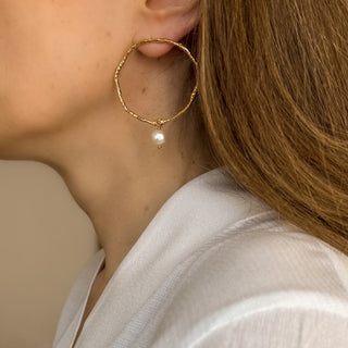 Boucles d’oreilles Arthur grand cercle doré avec perle blanche Youm, portées.