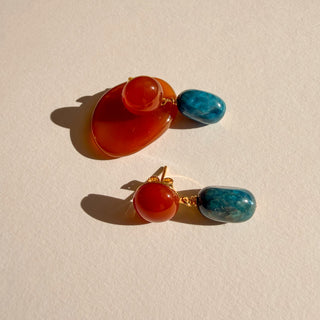 Boucles d’oreilles Azul dorées, détail posé mettant en valeur les pierres naturelles la cornaline, l’apatite et la finition en or fin 24 carats.