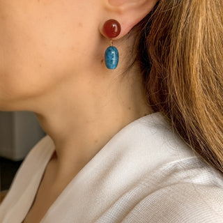 Boucles d’oreilles Azul pendantes dorées en cornaline et apatite portées, montrant la longueur, l’éclat de la dorure et les nuances naturelles des pierre colorées, disponibles en percées ou clips.