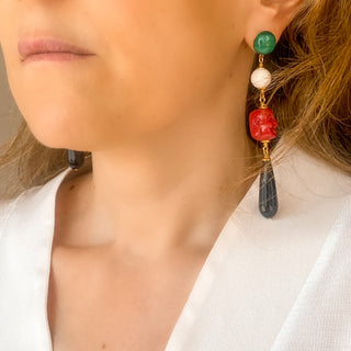 Boucles d’oreilles Céleste dépareillées et pendantes en pierres naturelles portées, montrant l’asymétrie, les couleurs contrastées et l’éclat de la dorure, disponibles en percées ou clips.