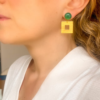 Boucles d’oreilles Claude pendantes dorées en agate verte portées de profil, montrant la longueur, l’éclat de la dorure et les nuances de la pierre naturelle, disponibles en percées ou clips. 