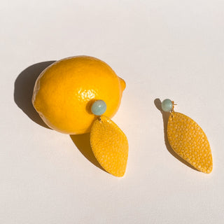 Boucles d’oreilles Gloria en galuchat jaune, détail posé mettant en valeur la texture du galuchat, la pierre amazonite et la finition dorée à l’or fin 24 carats.