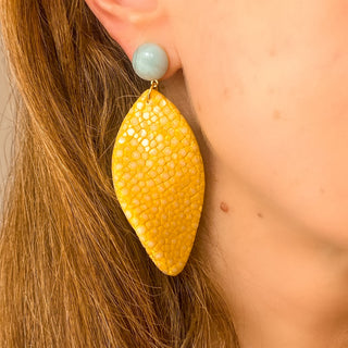 Boucles d’oreilles Gloria en galuchat jaune portées, montrant la longueur totale de 7,5 cm et le pendant en galuchat de 3 cm, avec pierre amazonite, disponibles en percées ou clips