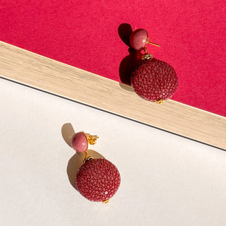 Boucles d’oreilles Grace en galuchat bordeaux, détail posé mettant en valeur la texture du galuchat, la pierre rhodonite et la finition dorée à l’or fin 24 carats.  