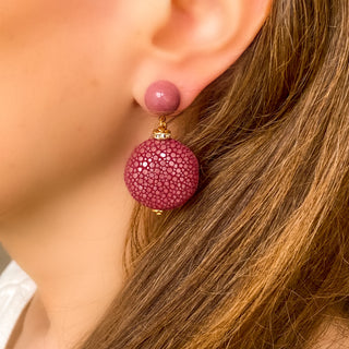 Boucles d’oreilles Grace en galuchat bordeaux portées, montrant la longueur totale de 5 cm et le pendant en galuchat de 2,5 × 2,5 cm, avec pierre rhodonite, disponibles en percées ou clips.