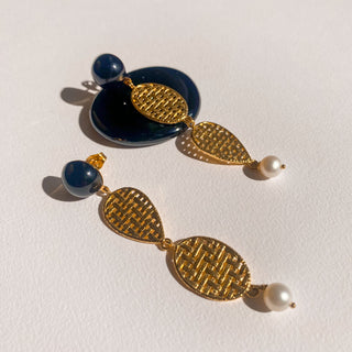 Boucles d’oreilles Liz pendantes dorées, détail posé mettant en valeur l’agate noire, les perles et la finition dorée, disponibles en version percées ou clips.