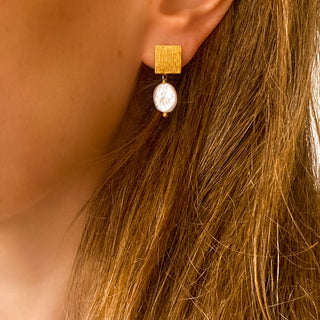 Boucles d’oreilles Neva dorées et perles blanches vue de profil, montrant la taille discrète, l’éclat des perles et la finesse du design, disponibles en version percées ou clips.