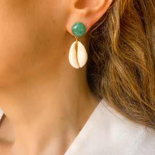 Boucles d’oreilles Océane pendantes dorées en coquillage cauri et amazonite portées, montrant la longueur, la texture du coquillage et la douceur de la pierre naturelle d’amazonite, disponibles en percées ou clips. 