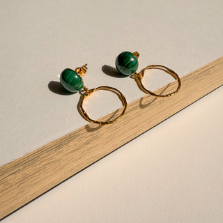 Boucles d’oreilles Orso petit rond doré avec pierre naturelle malachite Youm, finition or fin 24 carats, portées, pour oreilles percées ou clips, photo posée.