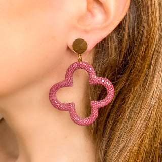 Boucles d’oreilles Trèfle en galuchat bordeaux, détail posé mettant en valeur la texture du galuchat, la forme trèfle et la finition dorée à l’or fin 24 carats.