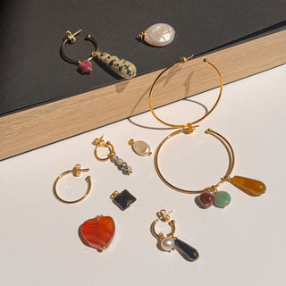 Charms en pierres et perles naturelles, détail posé mettant en valeur les couleurs et nuances des pierres et l’attache dorée à l’or fin 24 carats.