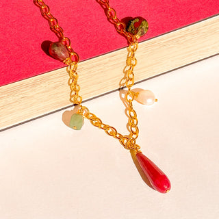 Collier Driss Youm posé à plat, lumière douce, mettant en valeur les perles et pierres naturelles.