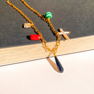 Collier Salomé Youm posé à plat, lumière douce, mettant en valeur les perles et pierres naturelles.