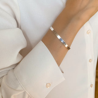 Jonc Ana argenté porté, bracelet rigide ajustable en laiton argenté, style fin et élégant.