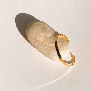 Jonc Ana doré, détail posé mettant en valeur la texture graphique, la finesse de 0,5 cm et la finition en or fin 24 carats.