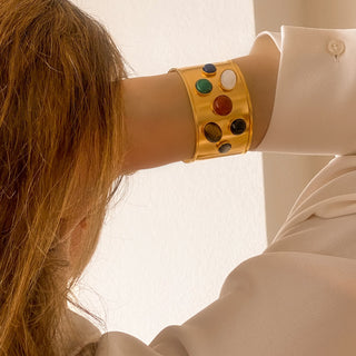 Manchette Iris dorée portée de face, montrant les pierres naturelles, la brillance de la dorure et l’ajustement du bracelet.