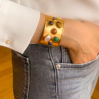 Manchette Iris dorée portée de profil, montrant les pierres naturelles, la brillance de la dorure et l’ajustement du bracelet.