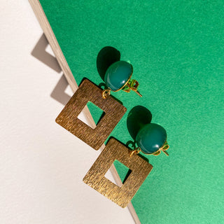 Boucles d’oreilles Claude dorées, détail posé mettant en valeur la pierre naturelle d’agate verte et la finition en or fin 24 carats