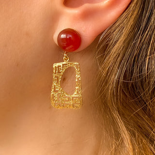 Boucles d’oreilles Gustave pendantes dorées en cornaline, style Art Déco, déatils portés pour montrer la longueur, le mouvement et l’élégance vintage, disponibles en percées ou clips.