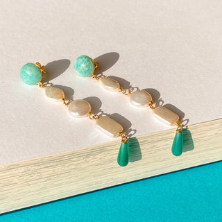 Boucles d’oreilles Zelda longues dorées, détail posé mettant en valeur les pierres naturelles l’amazonite, les perles blanches, l’onyx vert et la finition dorée, pour oreilles percées ou non percées.