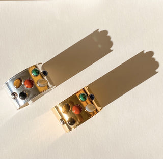 Manchettes Iris dorée et argentées, détail posé mettant en valeur les pierres naturelles, la texture et la finition en or fin 24 carats ou la finition argentée.